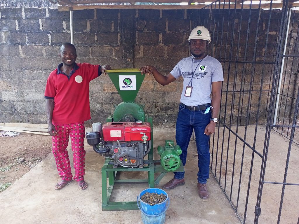Uche (right) and Mr. Uzor and the donated a palm kernel cracking and separating machine